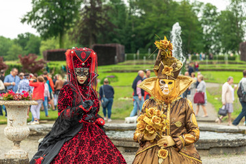 ANNEVOIE GARDENS, BELGIUM - June 9, 2019: Women standing in masks and masquerade costumes during Venetian carnival in Annevoie  gardens, Rue des jardins, 37 a, Annevoie/ Belgium - 311239175