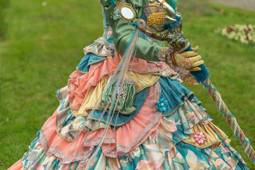 A woman standing in masquerade costume in summer park - 311239301