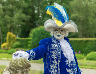 A man standing in mask and masquerade costume in Annevoie  gardens, Belgium - 311239369