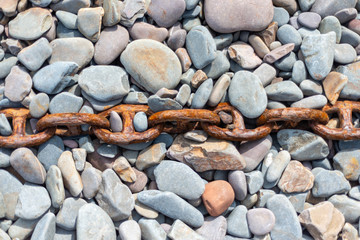 Rusty chain on pebble beach