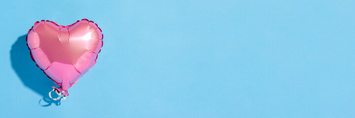 Air balloon heart shape on a blue background. Natural light. Banner. Concept love, wedding, photo zone. Flat lay, top view