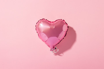 Forme de coeur de montgolfière sur fond rose. Lumière naturelle. Bannière. Concept amour, mariage, zone photo. Mise à plat, vue de dessus