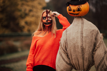 Young blonde girl with halloween face art posing outdoor.  Helloween celebration concept.