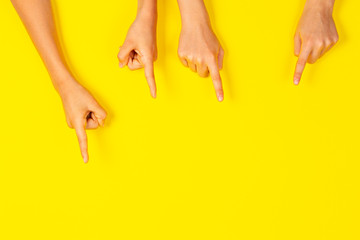 Many hands pointing to something on yellow background