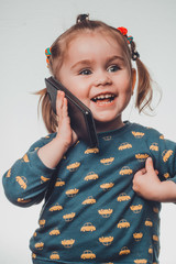 Cute and sincere beautiful girl talking on the phone, portrait of girl 3-4 years.