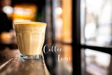 Coffee time. Time for me. Glass with coffee on a wooden table. Cappuccino with almond milk. Vegetarian drink. Relax with a cup of coffee. Latte by the window