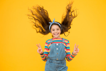 summer vacation joy. little child yellow background. old fashioned kid fashion. little beauty windy long hair. vintage style. happy childhood. retro girl cheerful gesture. hair fashion