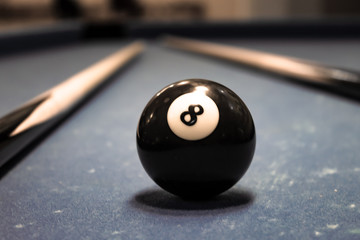 Billiard ball figure eight on a table with cues.