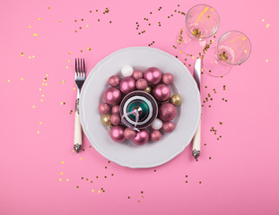 Christmas New year dinner concept pink color flat lay with dish and festive ornament inside on monochrome background