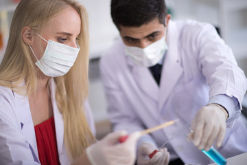 Male scientists and white female scientists are experimenting with chemicals in the laboratory.