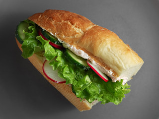 Sandwich with fresh vegetables on a ceramic gray plate. Vegetarian sandwich. Top view.