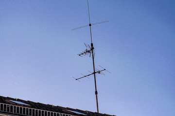 old analog antenna on a roof with blue sky