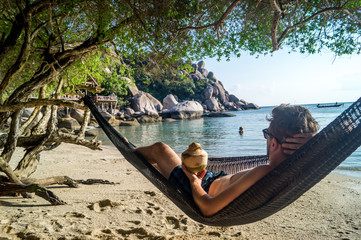 young man relaxing in hammock on the beach