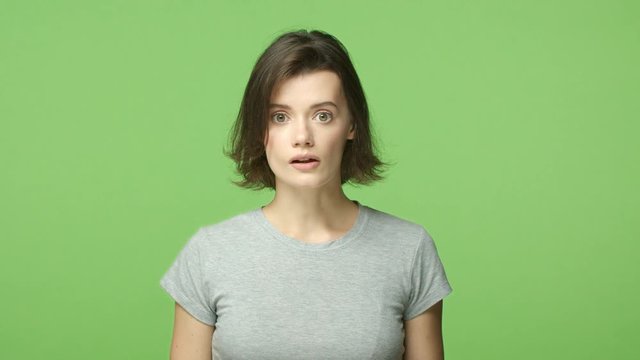 Slow-mo shocked woman in awe, open mouth astounded and wondered, gasping, holding breath startled, popping eyes camera, shopping see mush-have product, smiling in approval, green background