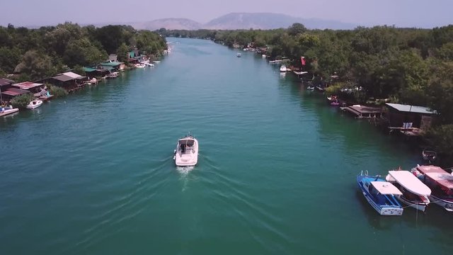 Drone view of a boat cruising on a river peacefully
