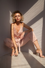 Portrait of a beautiful fashionable blonde woman in a pink jumpsuit