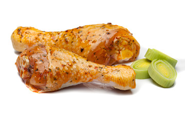Marinated chicken legs ready to cook on a white background