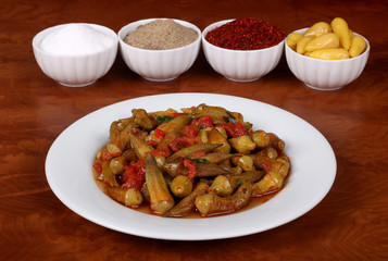 the one picture of Okra with red pepper and turkey spices on white plate on wooden bamya table for Hotel & Restaurant Orders and Menu and Internet and TV