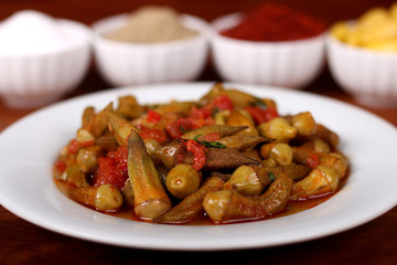 Okra with red pepper and turkey spices on white plate on wooden bamya table for Hotel & Restaurant Orders and Menu and Internet and TV