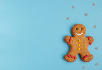 Gingerbread man  on blue background with stars , Flat lay, Christmas and  new year concept,  top view,  copy  space 