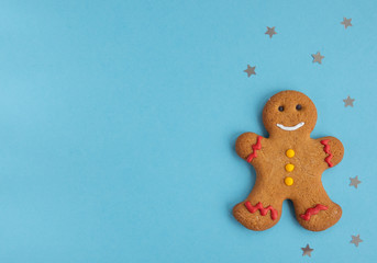 Flat lay with Gingerbread man  on blue background with stars , Christmas and  new year concept,  top view,  copy  space 