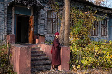 Fototapeta premium A woman stands on the porch of an vintage country house.