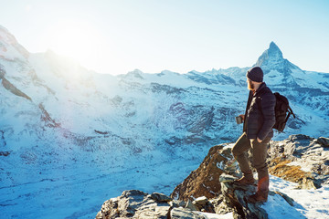 Traveler Man with backpack trekking in mountains, enjoy beautiful Matterhorn view. Explorer man...