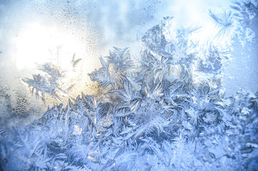 Blow snowflakes and patterns on glass in winter