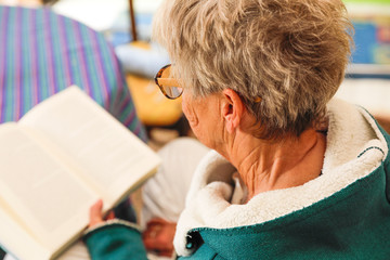 Fototapeta na wymiar Frau am Buch lesen mit Brille ganz entspannt