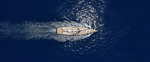 Aerial drone ultra wide photo of luxury sail boat with wooden deck cruising deep blue Aegean sea,...