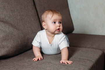 Little baby crawls on the bed. The appearance of a child in the family. Emotions child.