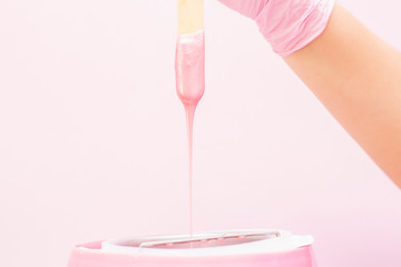 liquid wax for pink depilation drains from the stick. The concept of depilation, waxing, smooth...