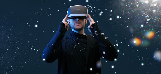 Young man on virtual reality background. Guy using VR helmet. Augmented reality, future technology, game concept.