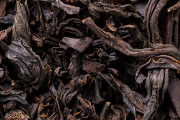 Black tea background. Fermented leaves for meking helthy hot drink. Horizontal