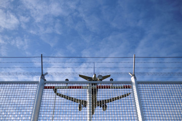 Landendes Flugzeug &uuml;ber Sicherheitszaun am Flughafen - Stockfoto