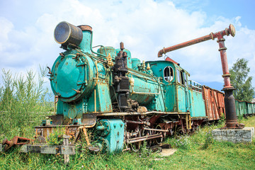  Abandoned old narrow-gauge steam locomotive with freight cars