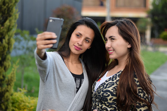 two women take a picture with the cell phone