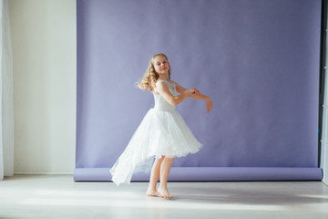 Beautiful little girl blonde dancing to music