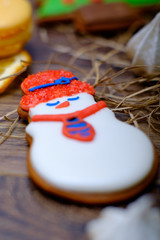 Christmas present set with sweets and oranges. Macaroons, gingerbread cookies set with snowman on wooden background. Vintage winter postcard.