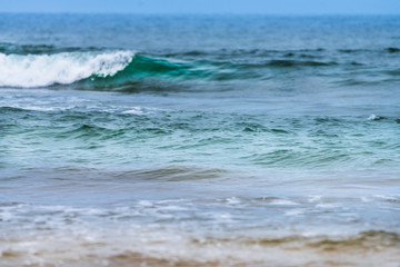 Raudasandur or red sandy beach in the westfjords of Iceland. Green and bluish waves are crashing ashore. Ocean, traveling concept.