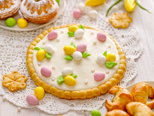 Fototapeta na wymiar Mazurek pastry, traditional Polish Easter cake made of shortcrust pastry with white chocolate cream, decorated with marzipan eggs and sugar pearls on the holiday table, close-up. Sweet dessert