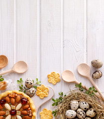 Easter background with  mazurek pastry and quail eggs on rustic white wooden background, top view, copy space. Traditional Easter 