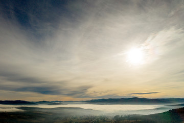 Fog in mountains before sunrise, mountain valley with clouds. View to mountains of the Carpathians