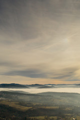 Naklejka na ściany i meble Fog in mountains before sunrise, mountain valley with clouds. View to mountains of the Carpathians