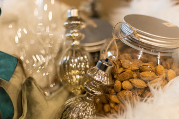 Elegante pacco natalizio con vaso di mandorle, decorazioni natalizie e bicchieri di Champagne