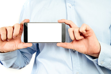 Phone in hand on a white background. A man holds a phone with a blank display in his hand. The concept of supplementing content, providing information.
