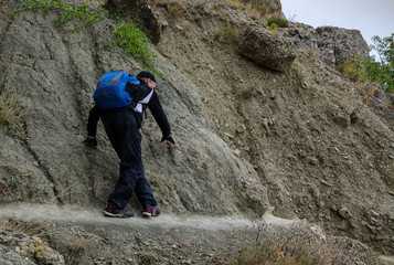 A man walking along dangerous mountain trails.