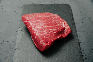 Raw beef, beef steak on a stone background. The concept of preparing a meal and eating. Fresh red...