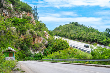 Highway through the mountain countryside. Vehicles driving in opposite directions on asphalt/...