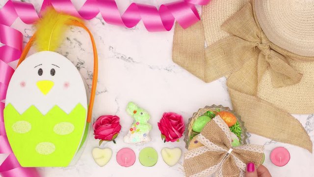 Easter decoration appear on marble background and woman's hand put bow on hat - Stop motion 